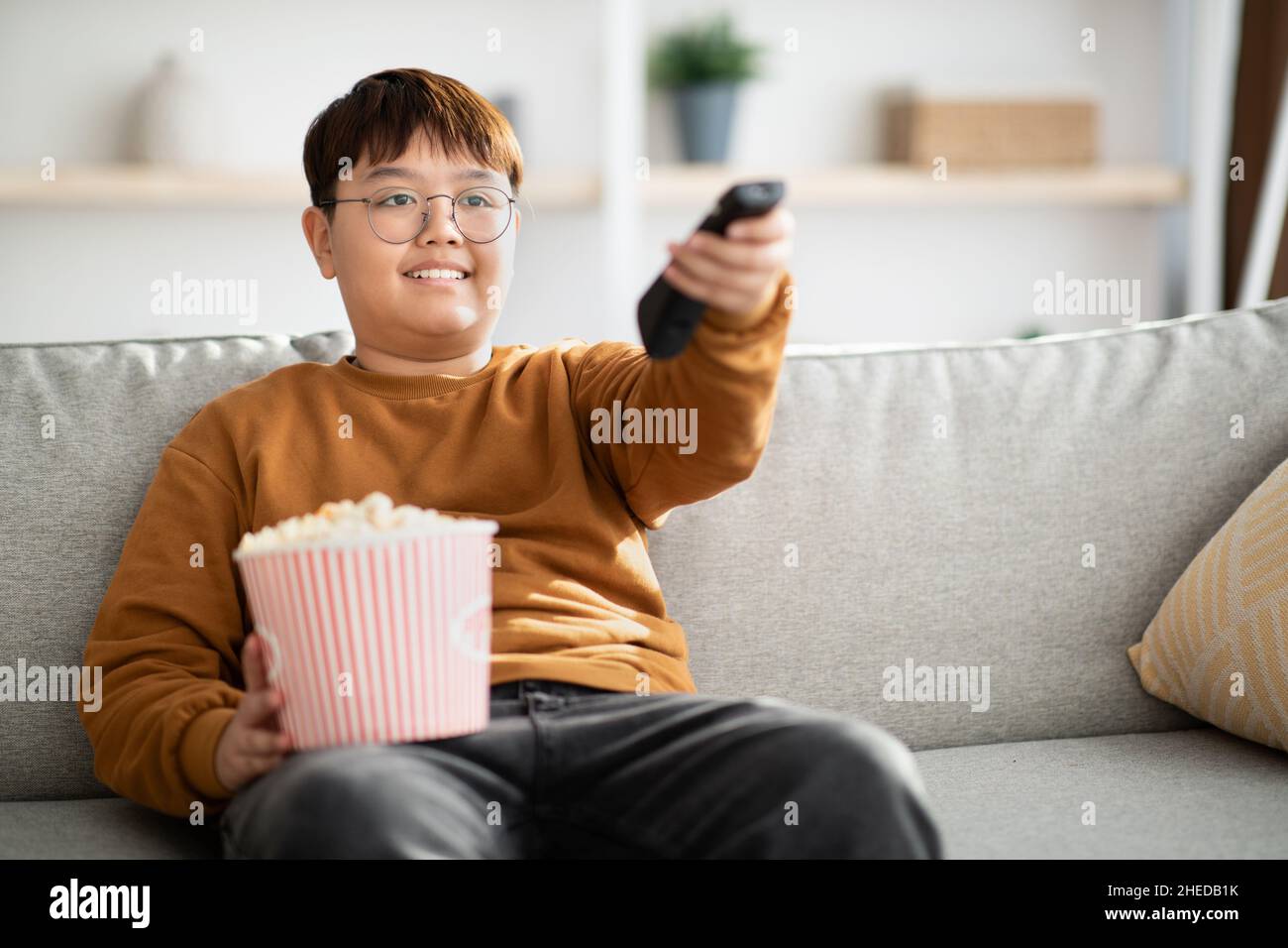 Rilassato bambino cinese guardando la TV a casa Foto Stock