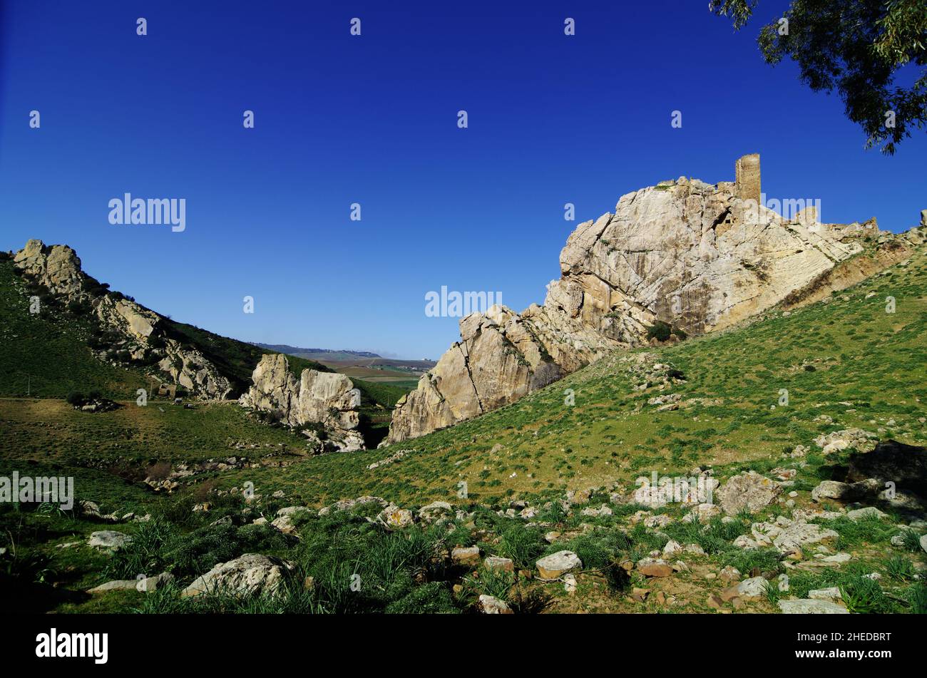 Falesia della Val Gresti con rupe rocciose e storica torre in pietra di Pietratagliata in Sicilia Foto Stock