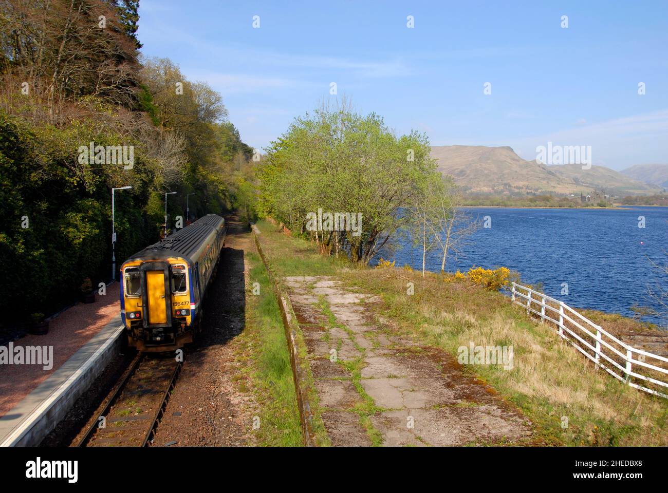 Stazione ferroviaria di Loch AWe a fianco di Loch AWe, in Scozia, operante come linea singola con seconda piattaforma, ora disutilizzata, coltivata a erbacce Foto Stock