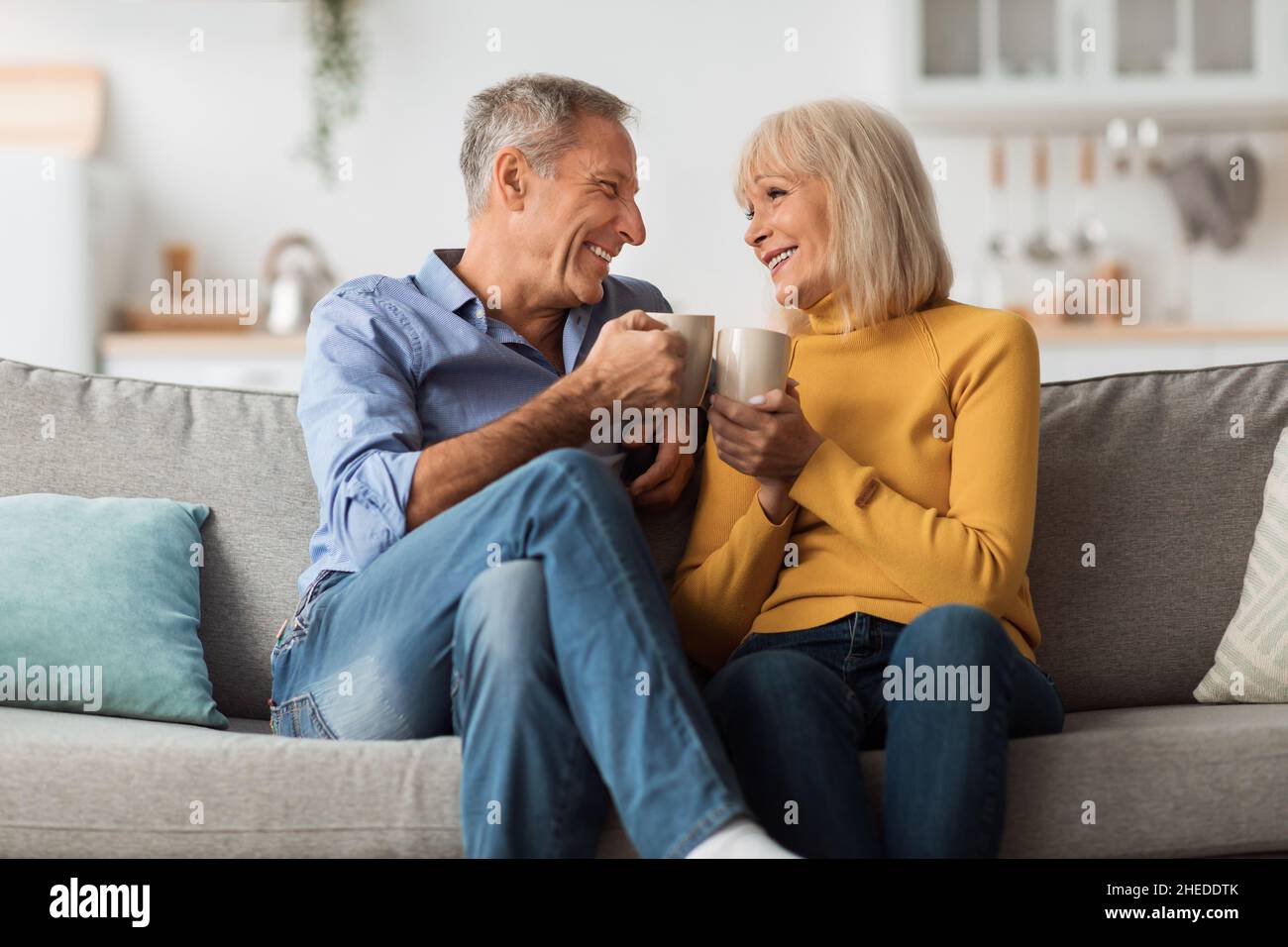 Allegro coppia matura bere caffè clinking Cups a casa Foto Stock