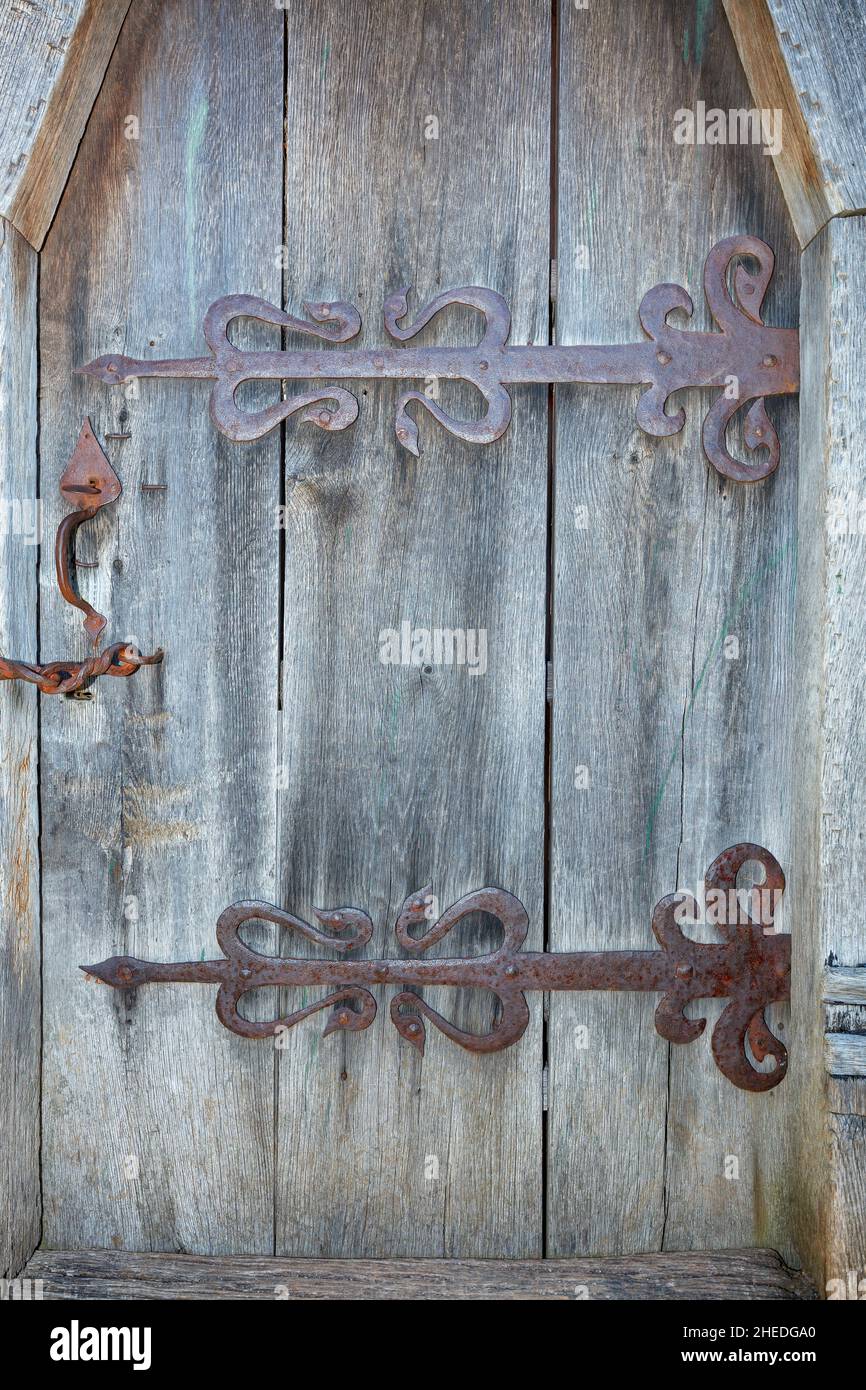 Porte in legno antico con intemperie e cerniere in metallo arrugginito. Primo piano. Spazio di copia. Immagine verticale. Foto Stock