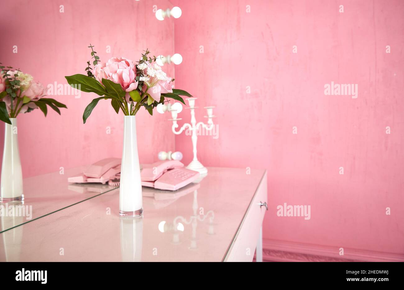 vaso su un tavolo in un interno rosa. spazio copia. Foto Stock