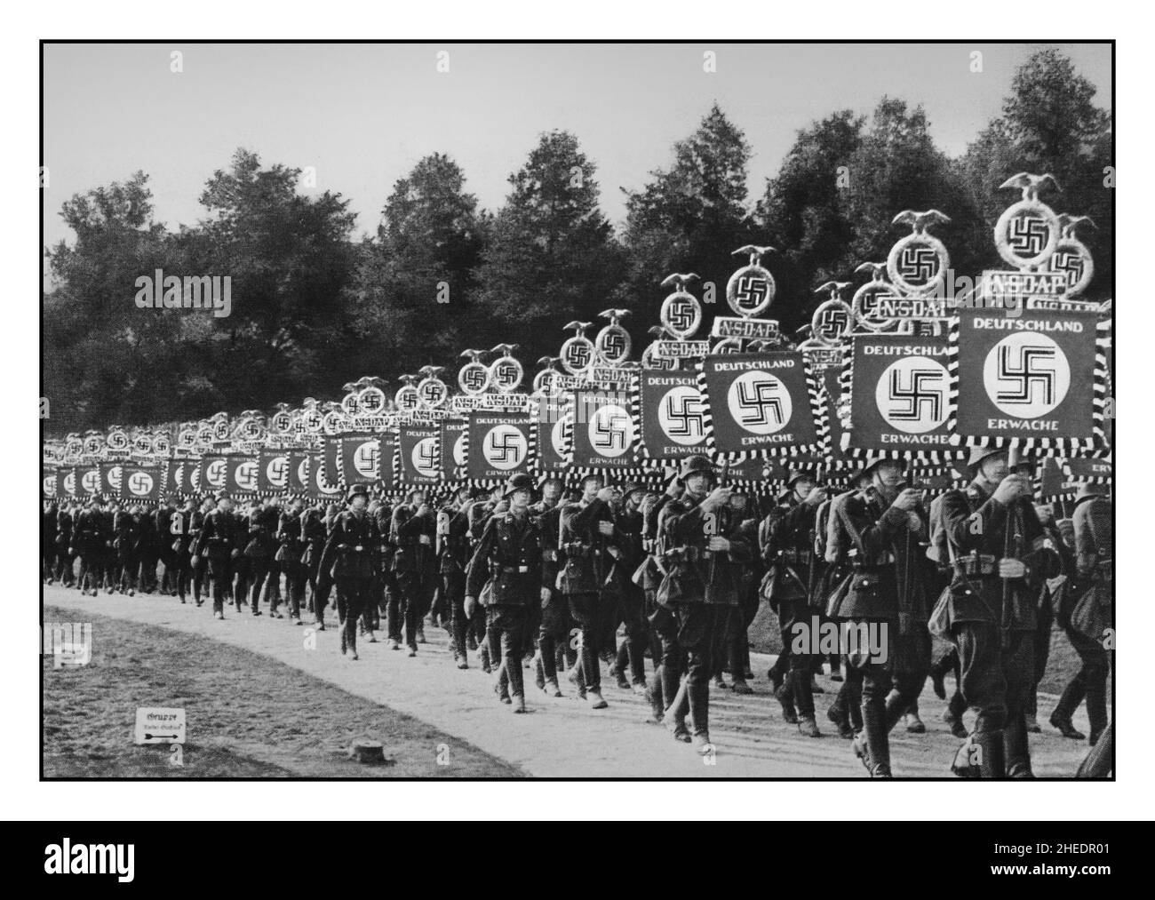 Truppe naziste SS che detengono striscioni con NSDAP Deutschland Erwache 'la Germania svegli' 'Congresso della Vittoria' (V Congresso del Partito Imperiale) Standard dello Schutzstaffel al Reichsparteitag, 1936 -in Norimberga Parata Norimberga Germania nazista Foto Stock