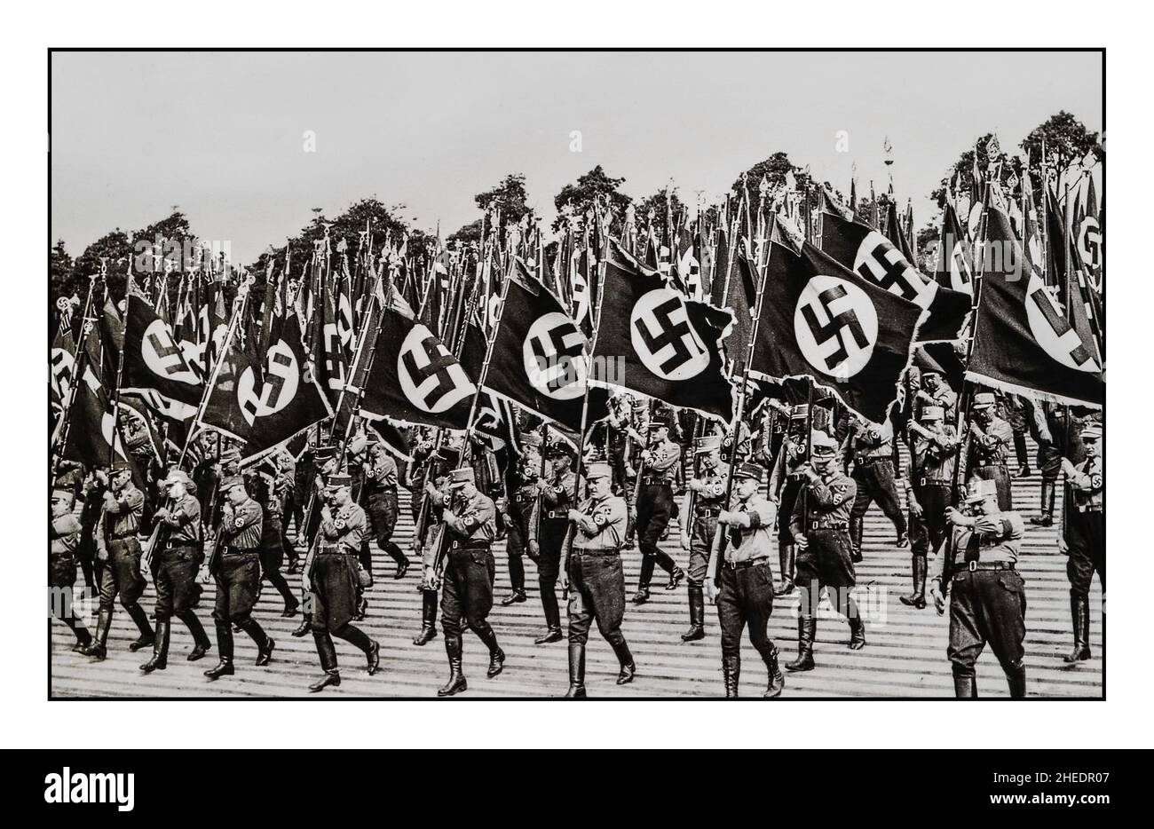 Lo Sturmabteilung, o SA, un'organizzazione paramilitare associata al Partito nazista. S.A. stormtroopers, o 'brownshirts', a Norimberga Germania, portacolori della bandiera della svastika alla festa del partito nazista a Norimberga , 1933. Foto Stock