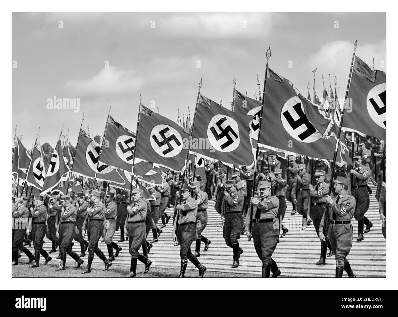 Lo Sturmabteilung, o SA, un'organizzazione paramilitare associata al Partito nazista. S.A. stormtroopers, o 'brownshirts', a Norimberga Germania, portacolori della bandiera della svastika alla festa del partito nazista a Norimberga , 1933. Lo Sturmabteilung era l'ala paramilitare originaria del partito nazista. Ha giocato un ruolo significativo nell'ascesa al potere di Adolf Hitler nel 1920s e nel 1930s. Foto Stock
