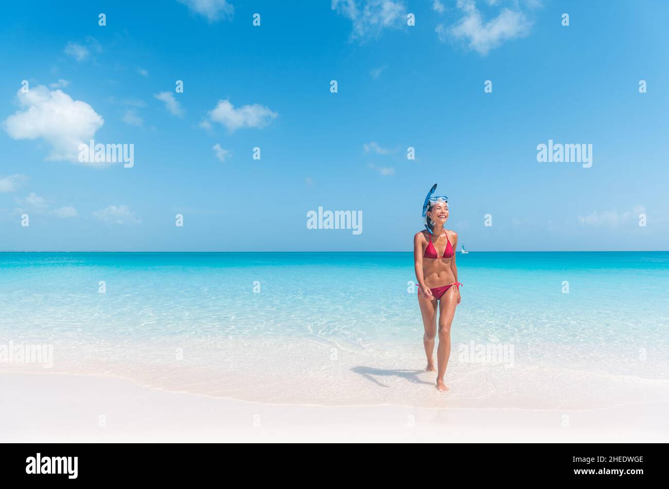 Donna bikini snorkeling divertirsi venendo da nuoto in acque cristalline oceano snorkeling nei Caraibi. Viaggio estivo in spiaggia stile di vita Foto Stock