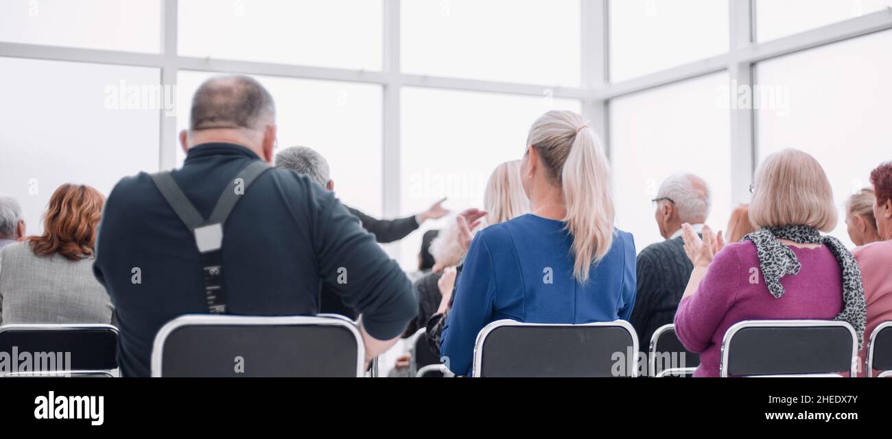 Il pubblico degli adulti ascolta il discorso del docente Foto Stock