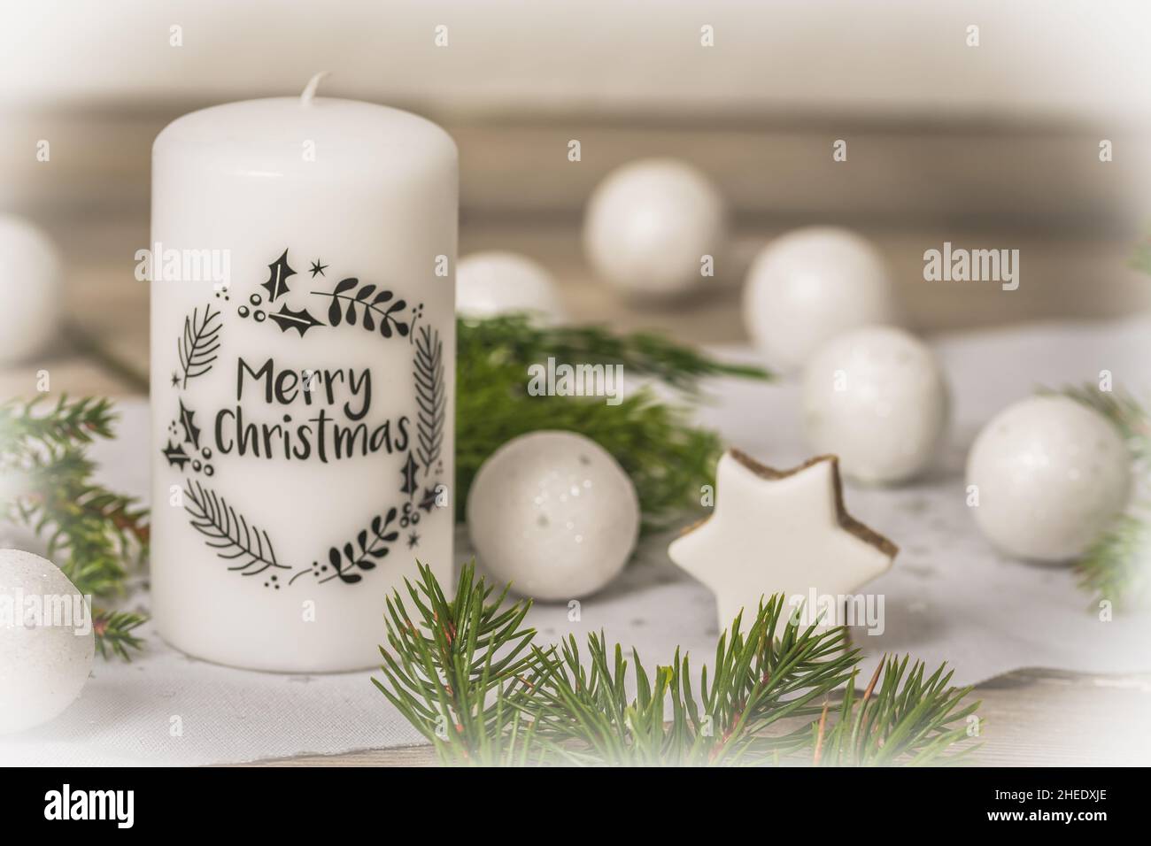 Candela bianca con testo nero buon Natale e decorazione di natale su tavola di legno Foto Stock
