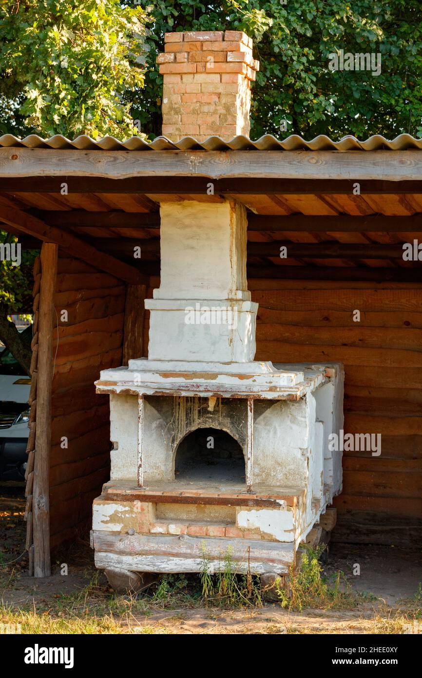 Un vecchio forno a legna per cucinare all'aperto si trova all'esterno sotto una tettoia di ardesia. Foto Stock