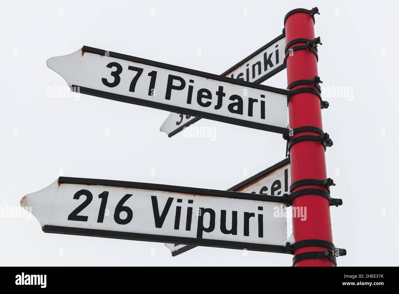 Segnaletica rossa, segnaletica direzionale con distanze dalle città di destinazione in finlandese. Savonlinna, Finlandia Foto Stock