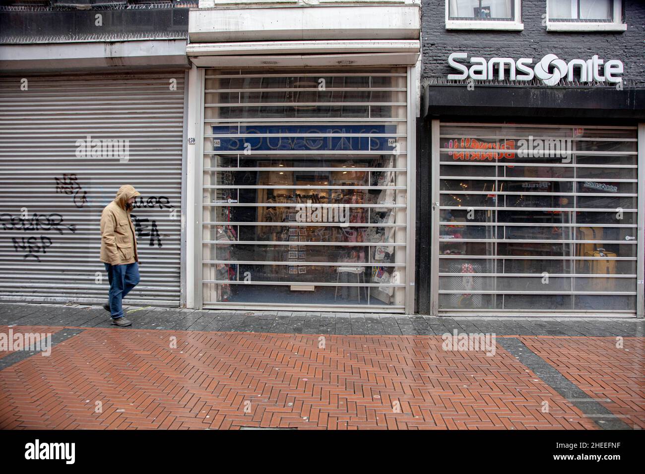 Amsterdam, Paesi Bassi. 09th Jan 2022. Un uomo è visto camminare accanto a un negozio chiuso con le persiane in metallo giù in via Nieuwendijk nel centro di Amsterdam.vita quotidiana ad Amsterdam durante la 4-settimana di blocco con i negozi non essenziali, ristoranti, caffè, bar, palestre, musei chiusi. (Foto di Nik Oiko/SOPA Images/Sipa USA) Credit: Sipa USA/Alamy Live News Foto Stock