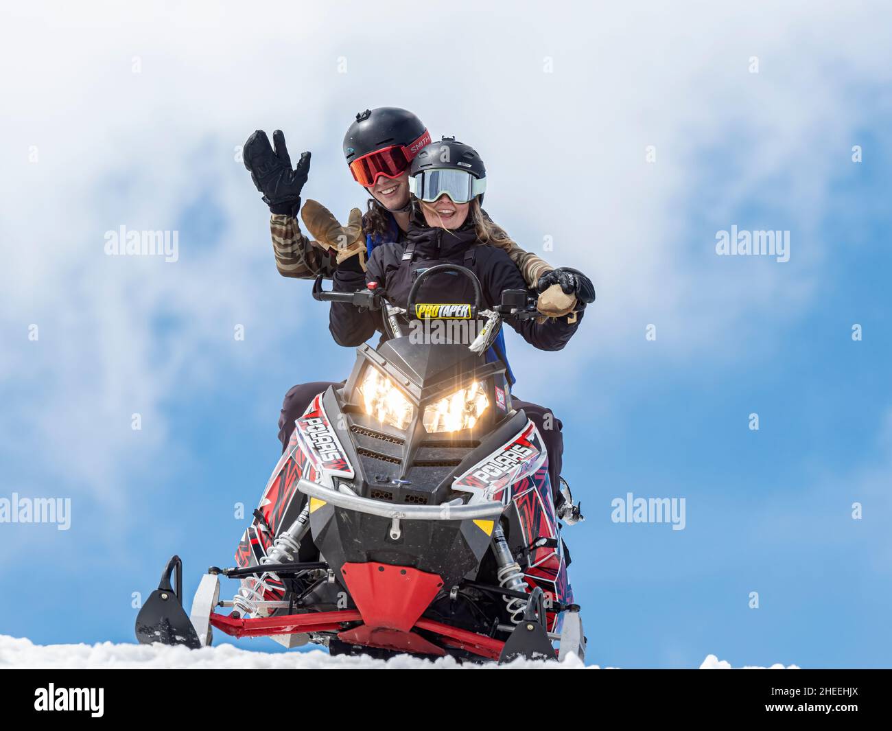 Una macchina da neve è guidata da due giovani piloti vicino a Beartooth Pass, Wyoming. Foto Stock