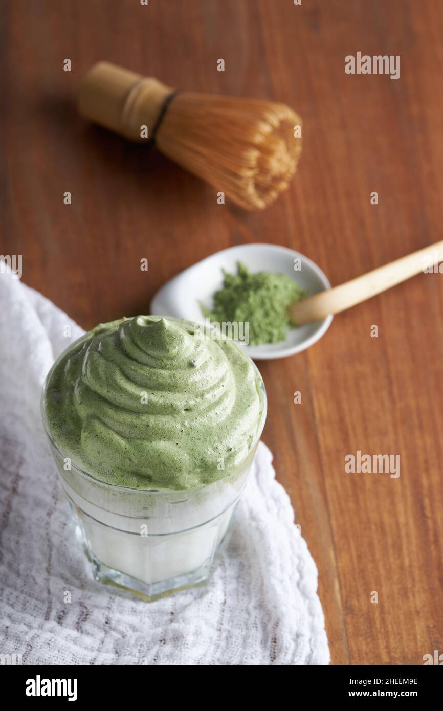 Da sopra un bicchiere di caffe' dalgona fresco con matcha e accessori per la cerimonia del te Giapponese che consistono in whisk di bambù chiamato chasen e tradizionale sc Foto Stock