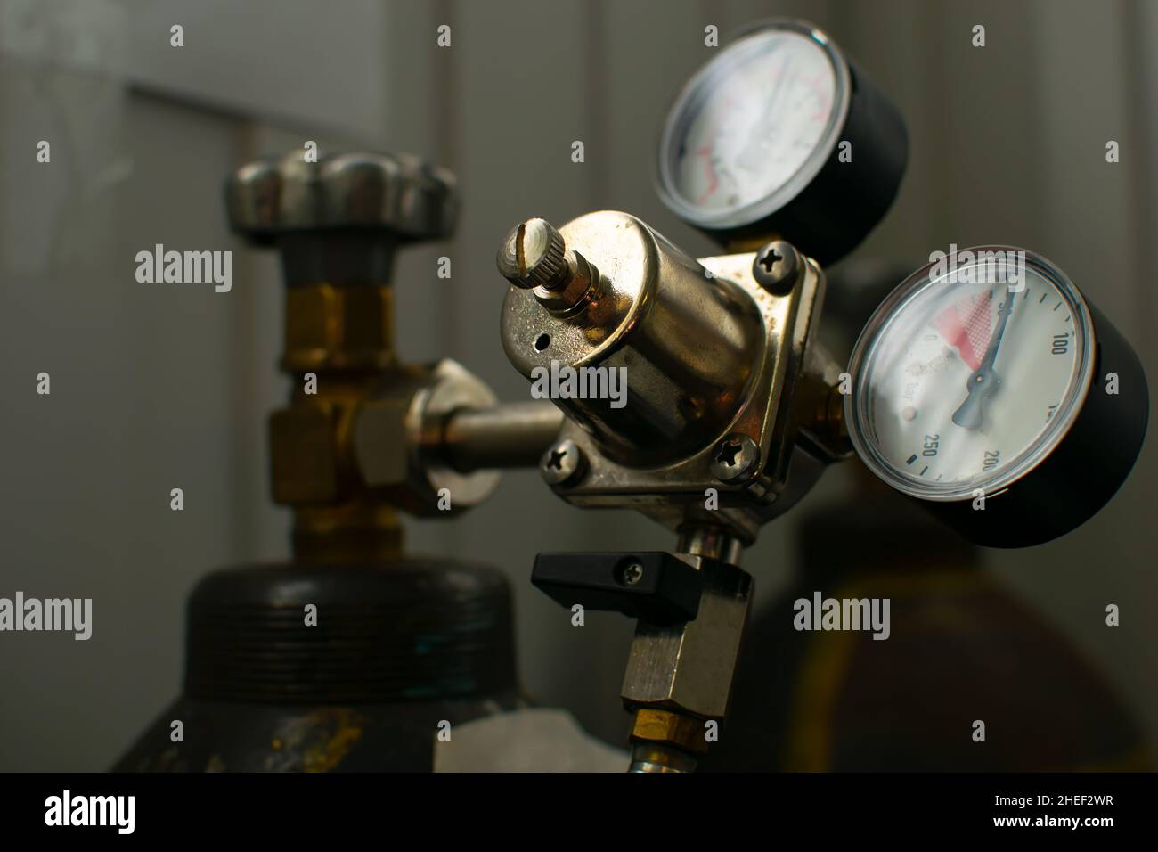 vista di dispositivi di commutazione, indicatori e un regolatore di pressione del gas, liquidi montati su una bombola di gas in metallo Foto Stock