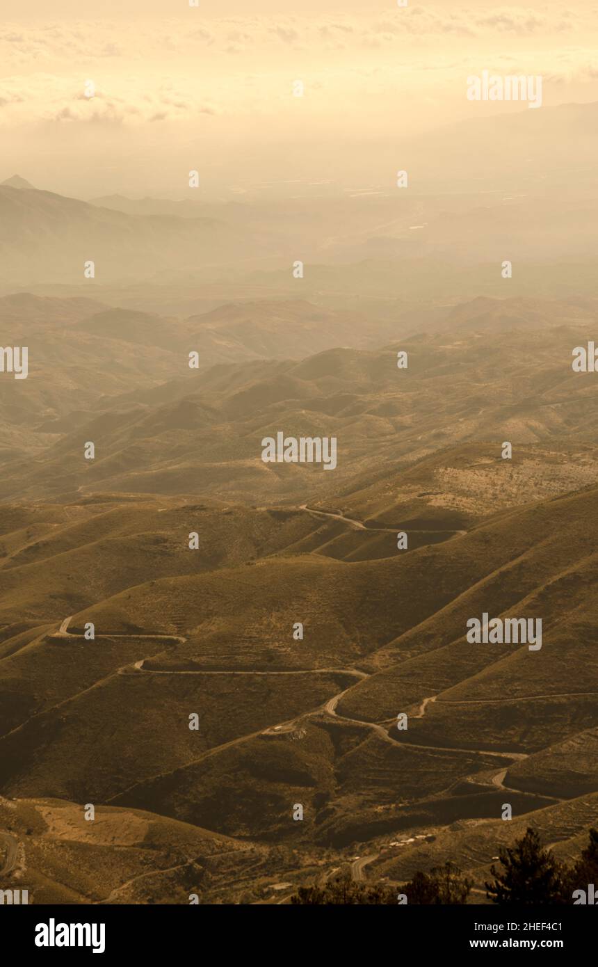 montagne, valli e gole di un deserto dove un sentiero desolato attraversa la desolazione Foto Stock