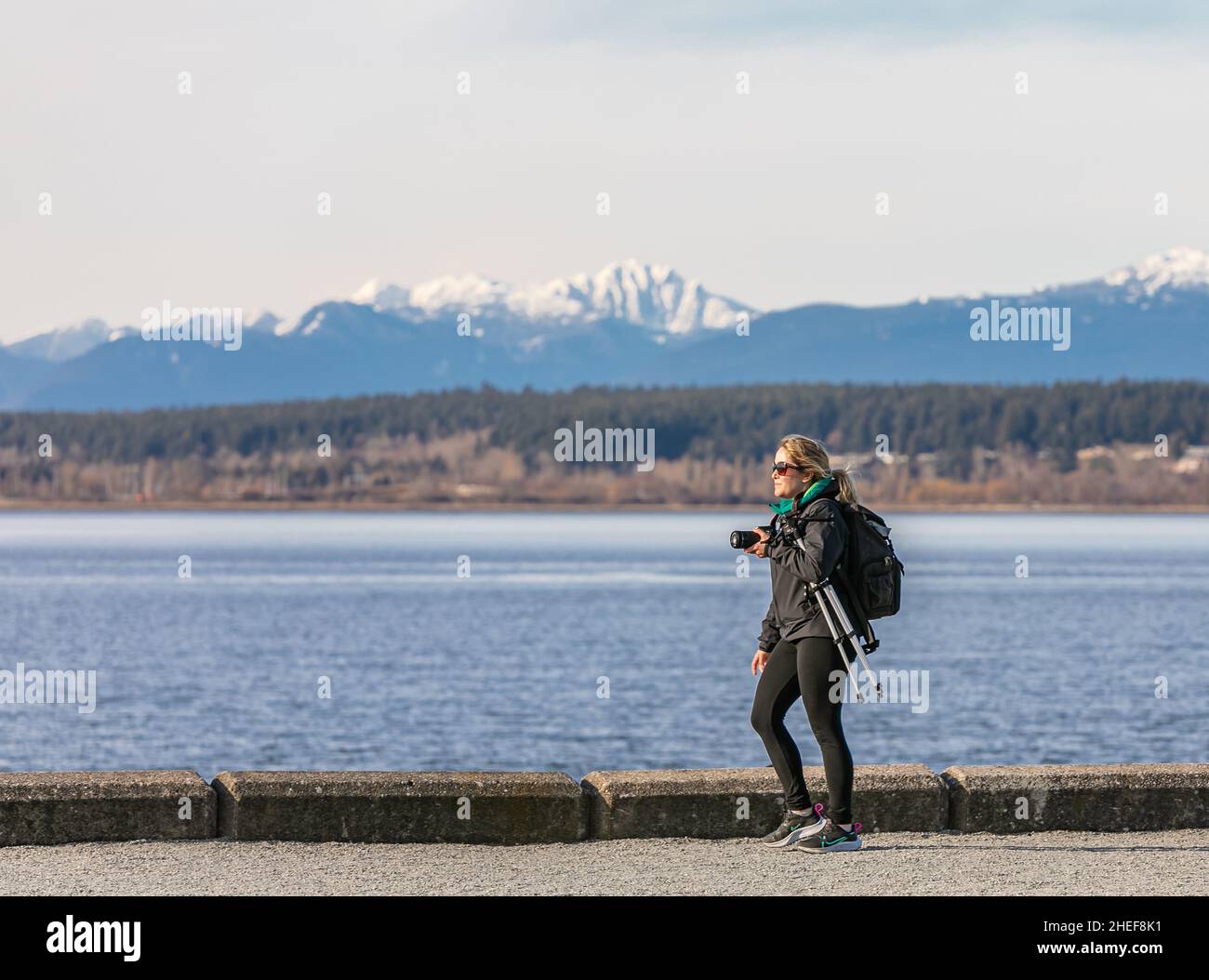 Photograper donna mano tenere macchina fotografica viaggiatore passeggiate nel parco. Street view, foto di viaggio, spazio di copia per il testo-Marzo 8,2021-White Rock BC, Canada Foto Stock