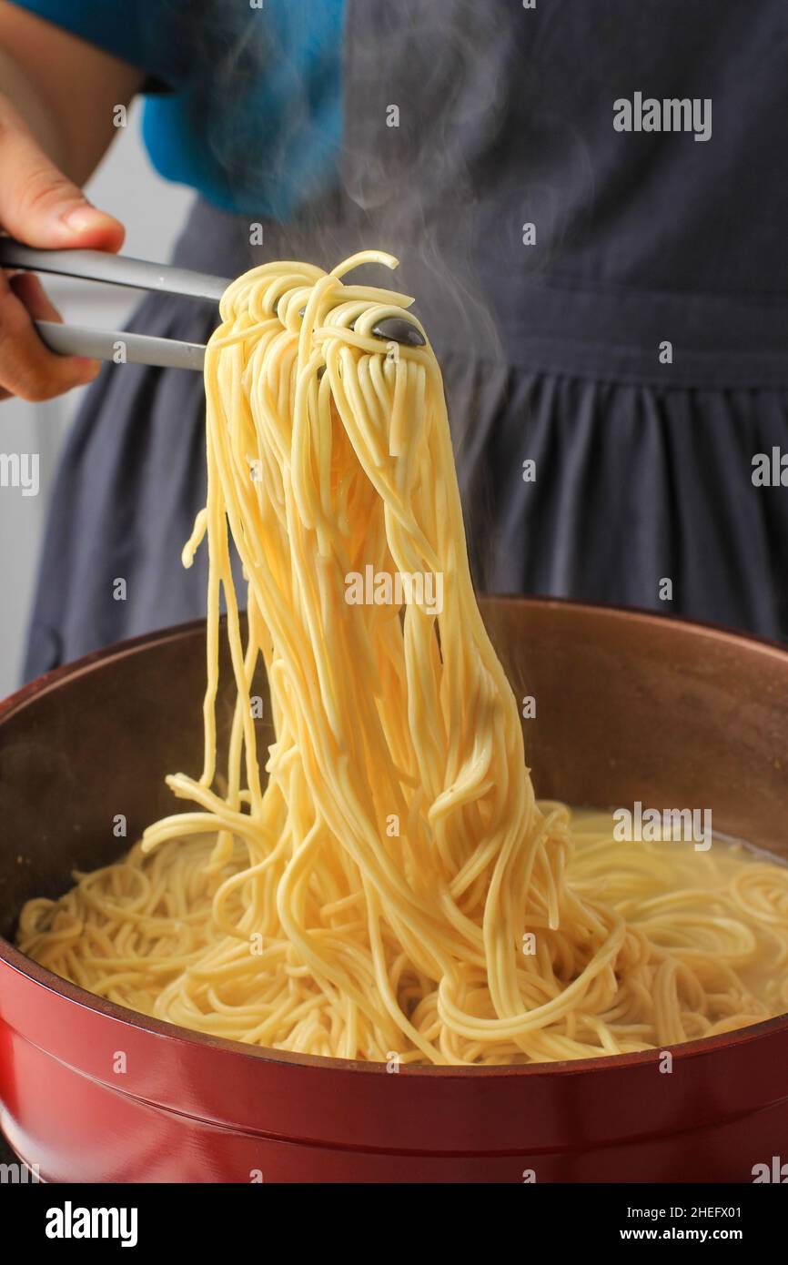 Asian Female bollito a mano Asian Noodle (mie Telur o bakmi), processo di cottura in cucina Foto Stock