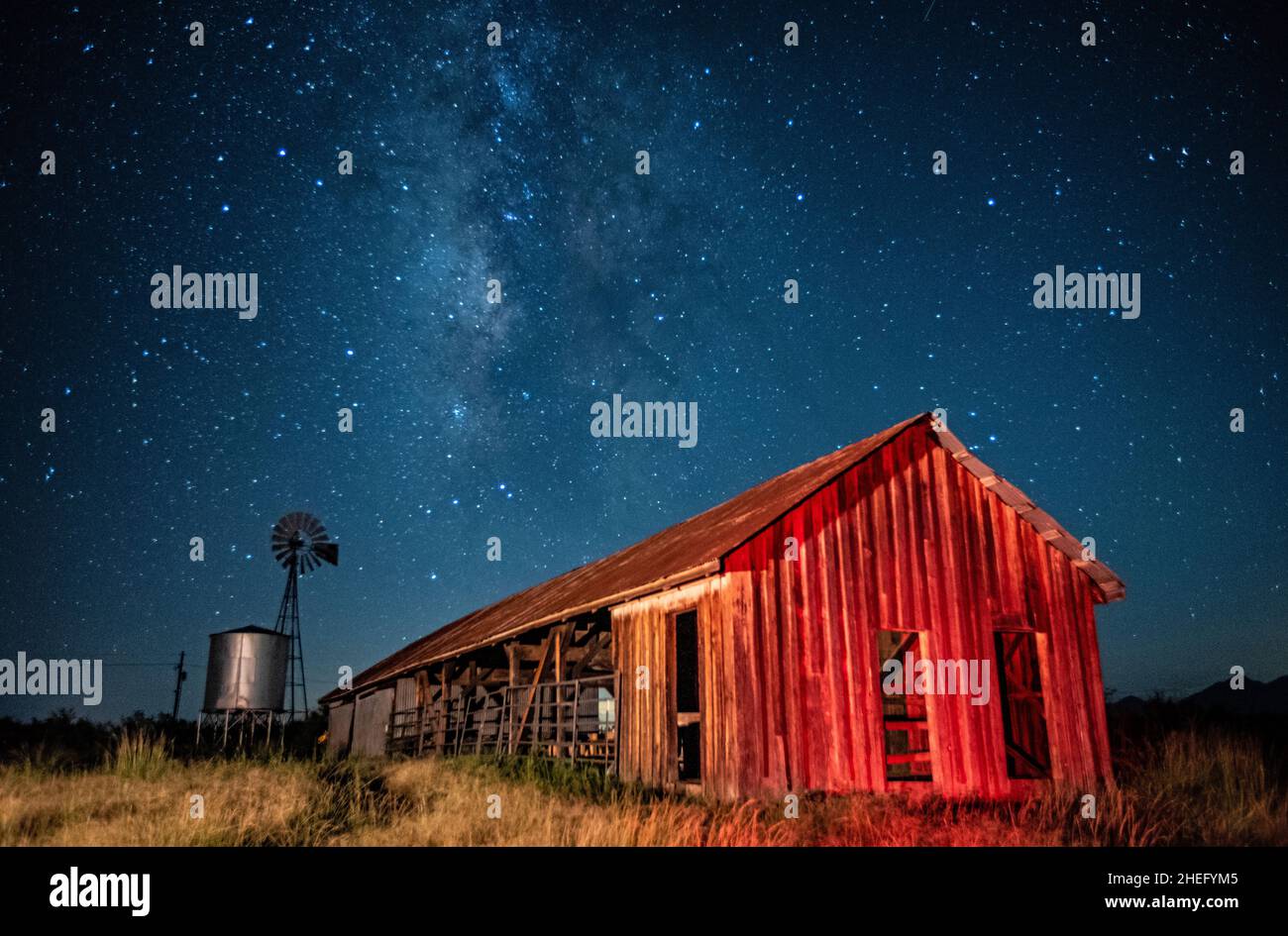 Vecchio fienile e mulino a vento sotto il modo lattiginoso Foto Stock