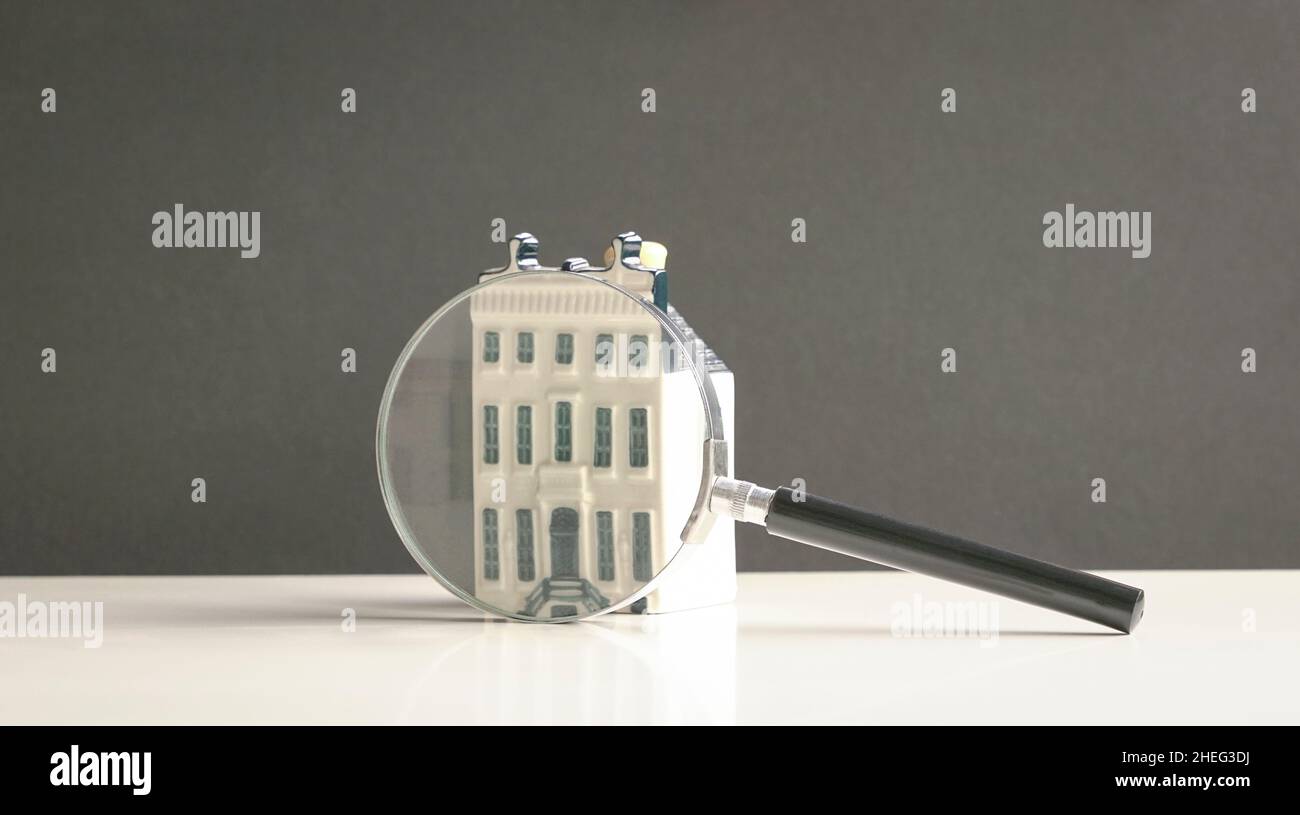 Mini albergo con lente d'ingrandimento. Ricerca del concetto di proprietà. Foto Stock