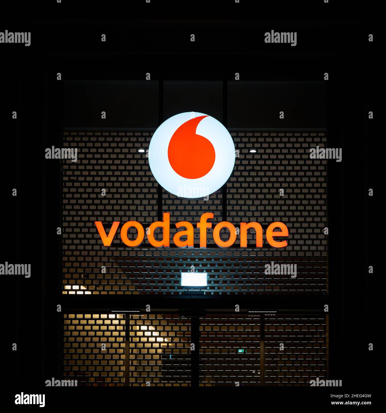 Pubblicità illuminata del fornitore di telefonia mobile Vodafone nel centro di Berlino in serata Foto Stock
