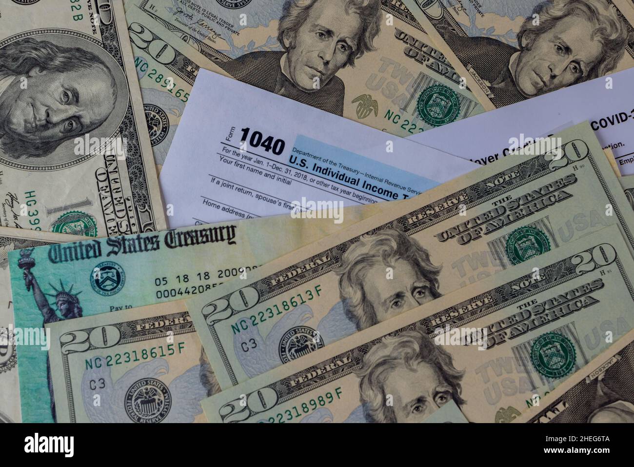 1040 modulo fiscale con assegno di rimborso e valuta banconote in dollari USA in primo piano Foto Stock