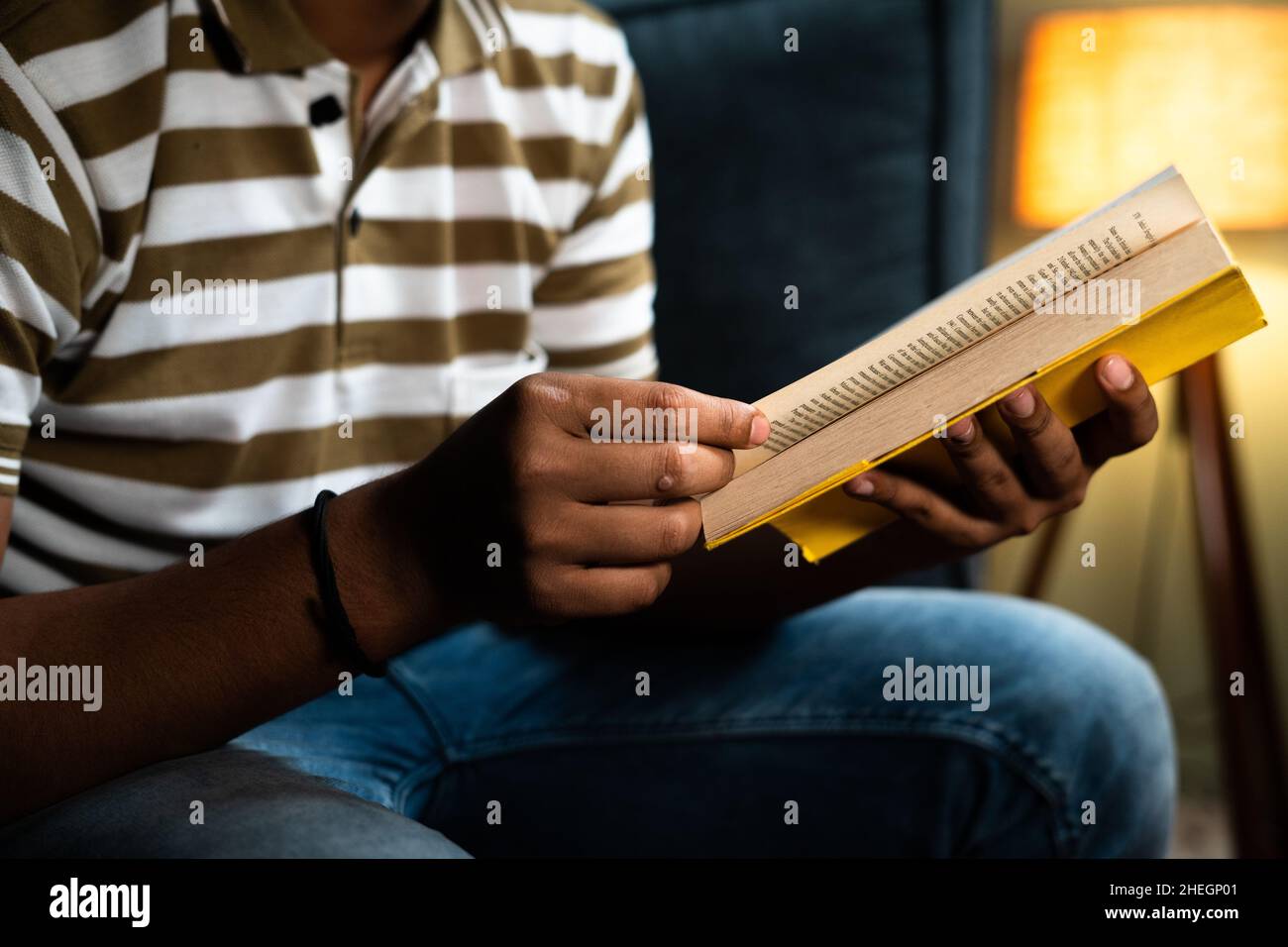 Focus su libro unrecognizible giovane uomo studiare libro prima di andare a dormire - concetto di novella lettura hobby, aspirante e lettura bedtime Foto Stock
