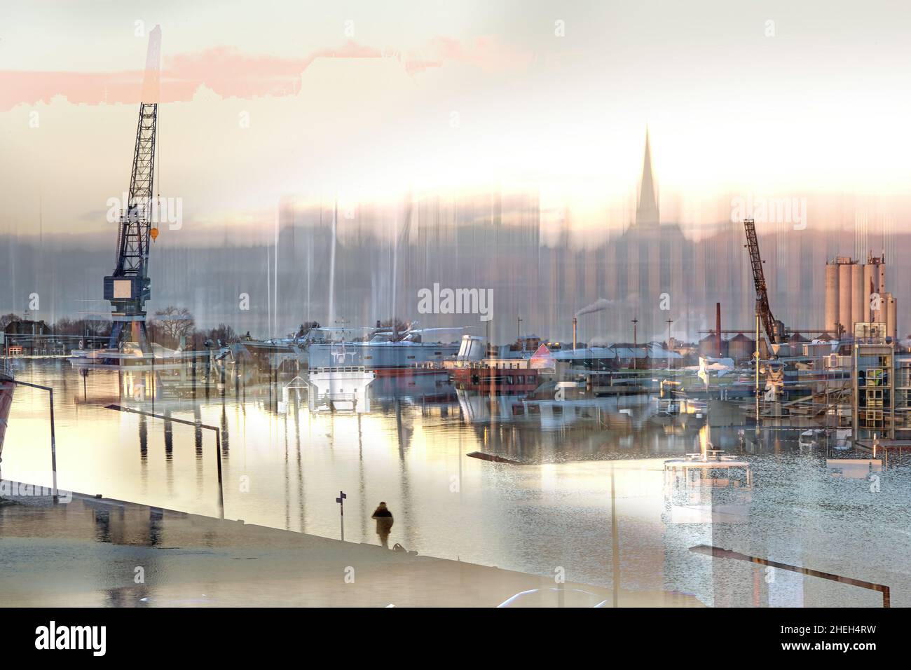 Scena sfuocata astratta nel porto di Lubeck con barche, gru e una persona di attesa in serata sole, a lungo termine e doppia esposizione con ICM o inte Foto Stock