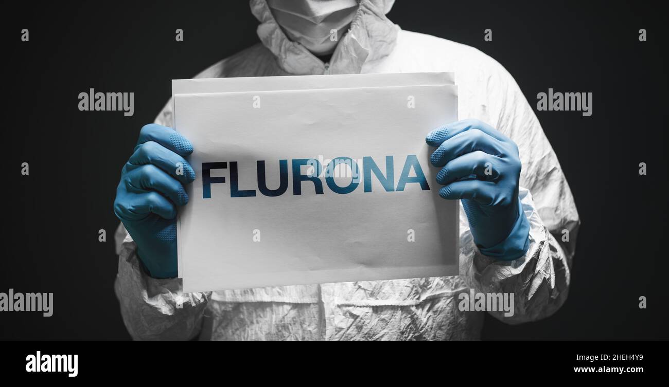 Flurona, infezione sia con influenza stagionale che con il coronavirus Covid 19, immagine concettuale con epidemiologo in possesso di white paper con testo, focu selettivo Foto Stock