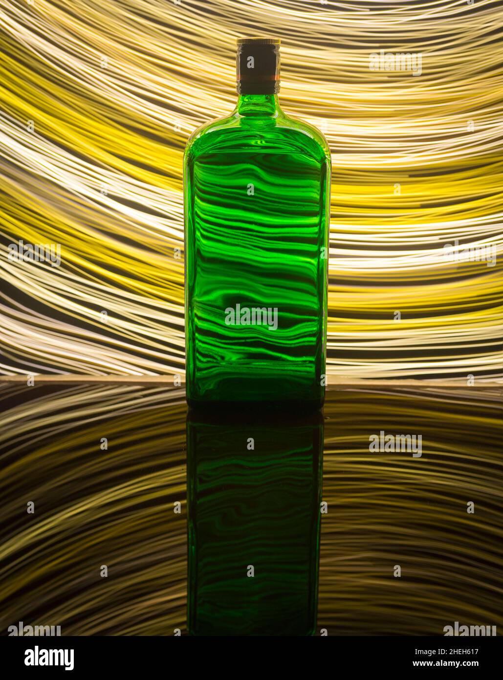 Una bottiglia verde sullo sfondo che è illuminata con pittura chiara. Foto Stock