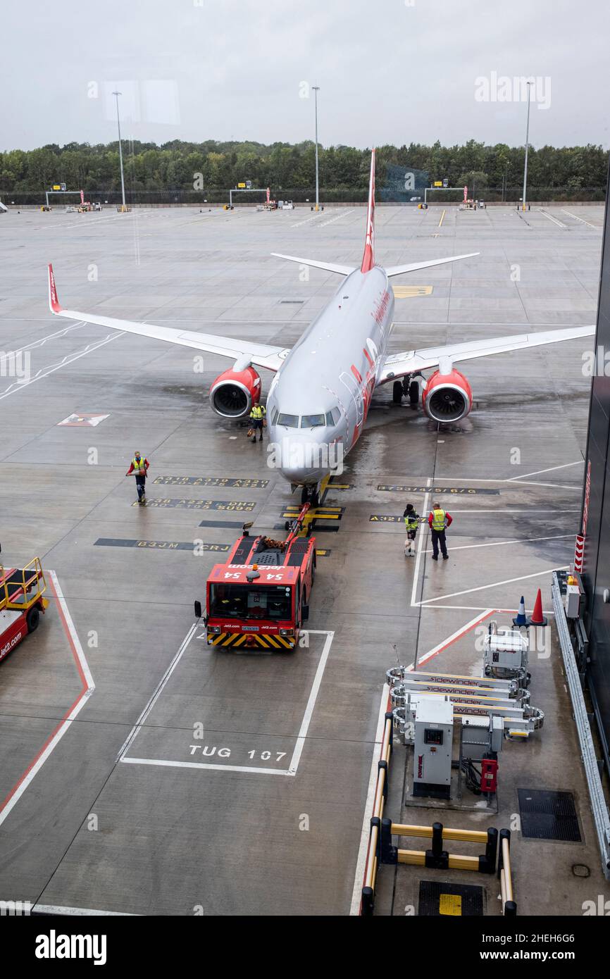 Aereo Jet 2 spinto indietro dal cancello visto dalla sala partenze all'aeroporto di Manchester, Inghilterra, Regno Unito Foto Stock