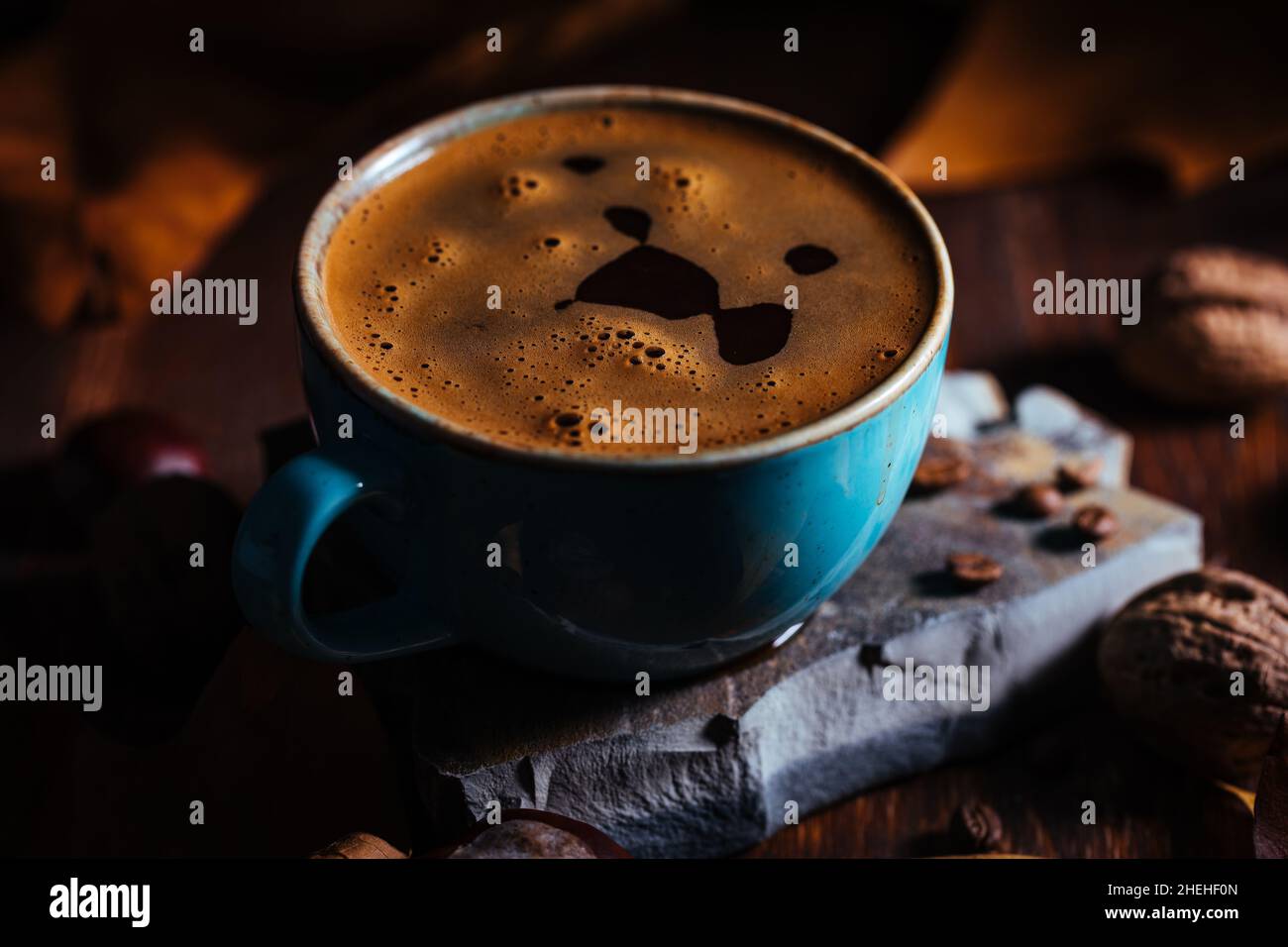 Tazza di caffè in porcellana blu in autunno, con foglie e chicchi di caffè dettagli in ambientazione e sfondo Foto Stock