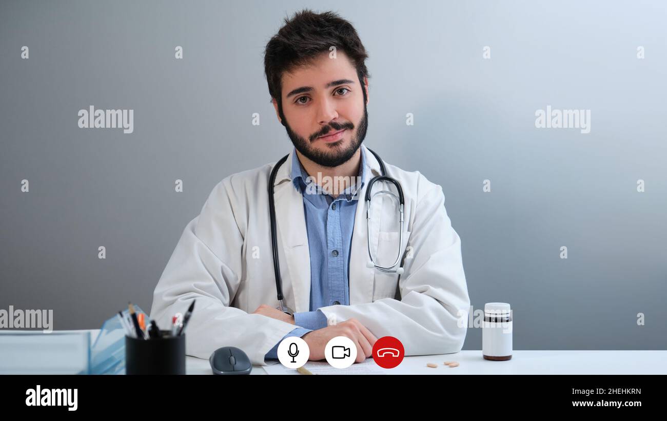 Videocall laptop screenshot di un giovane medico che guarda la fotocamera e sorridente. Foto Stock