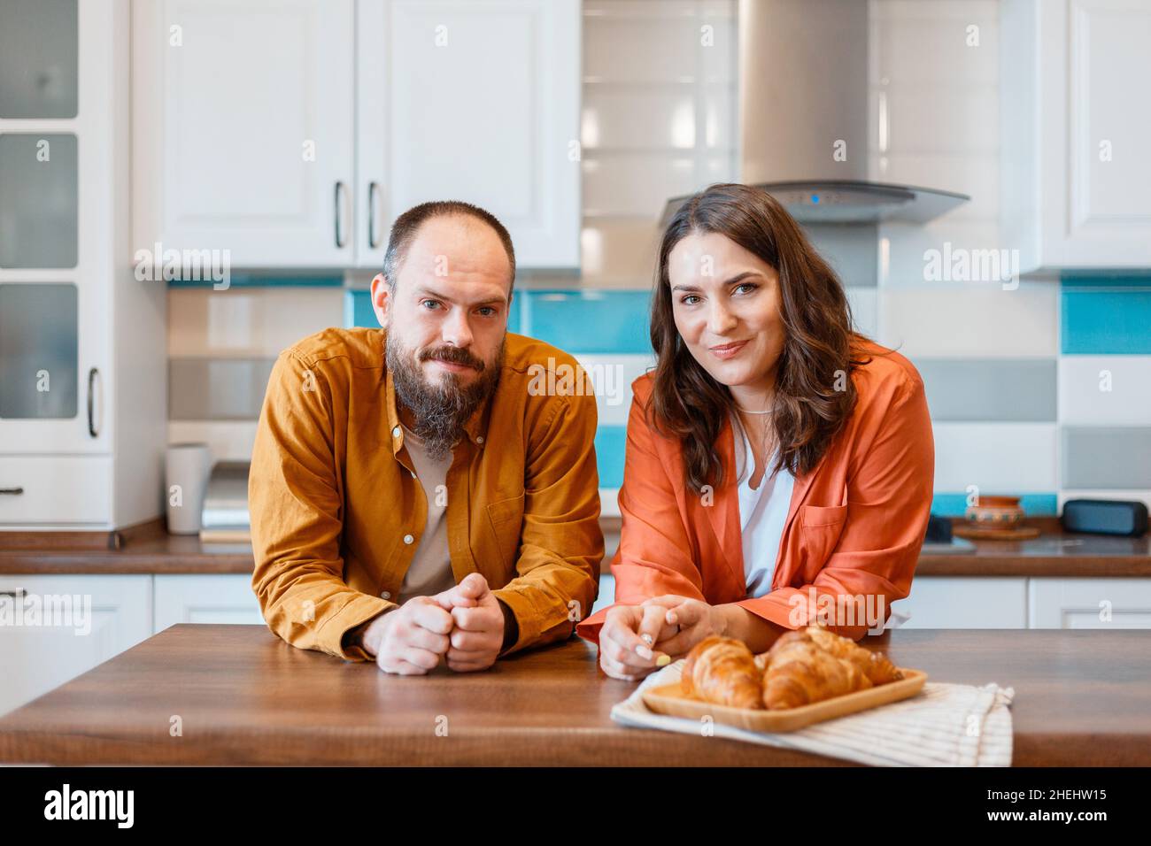 Felice giovane coppia che parla a casa in cucina. Famiglia marito e moglie si divertono a trascorrere il tempo insieme mentre si trova in appartamento interno. Famiglia Foto Stock