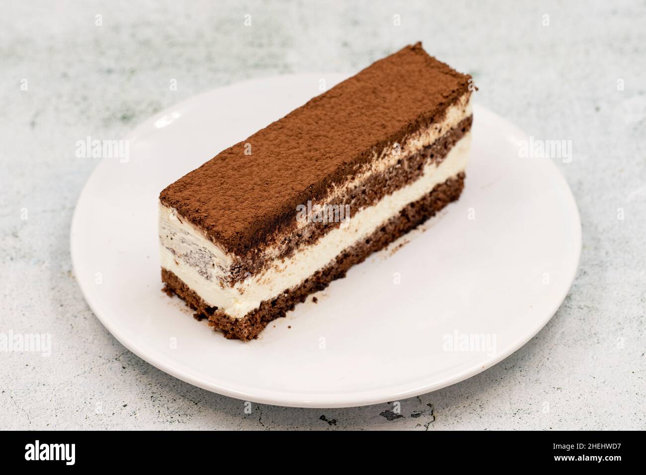 porzione di torta tiramisù su sfondo di pietra. Prelibatezze della cucina tradizionale del mondo. Primo piano. Foto Stock