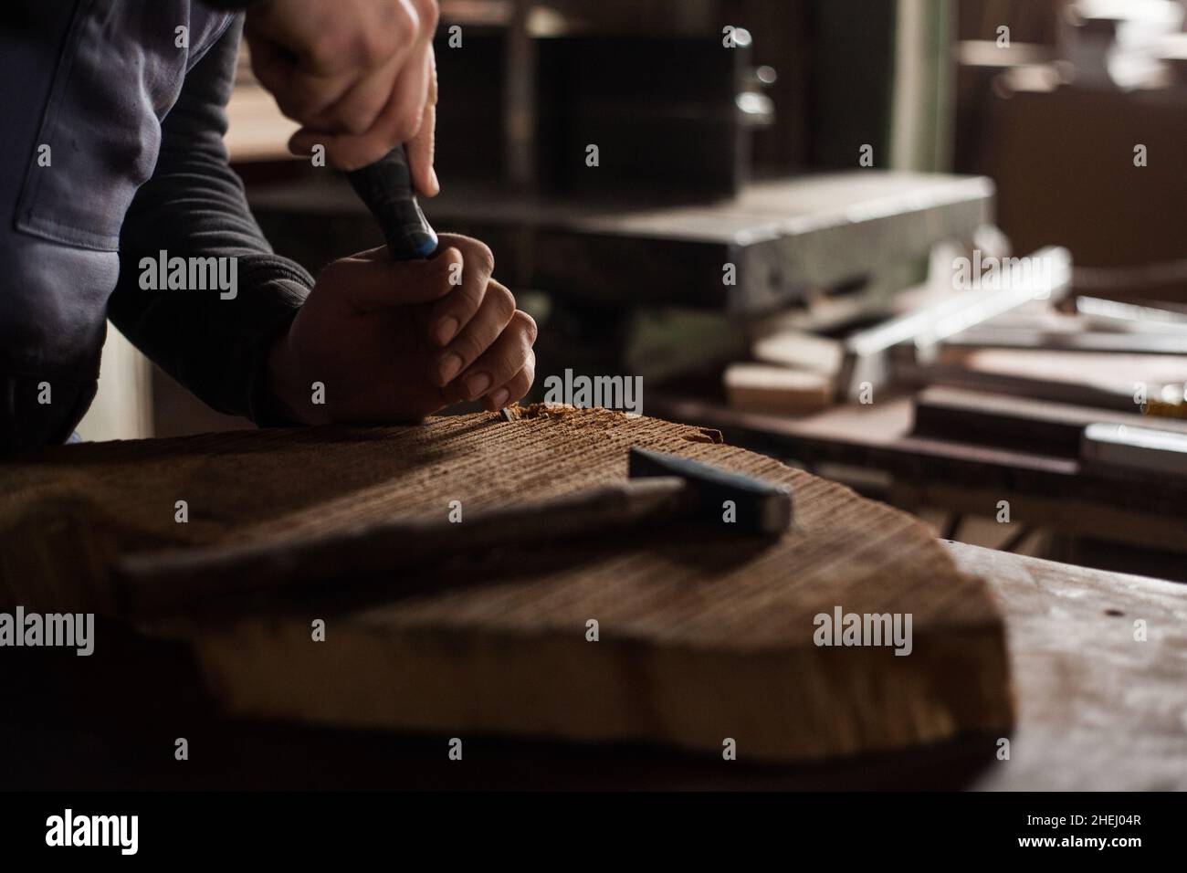 Giovane falegname maschio, giovane falegname maschio che fora in legno nella sua officina Foto Stock