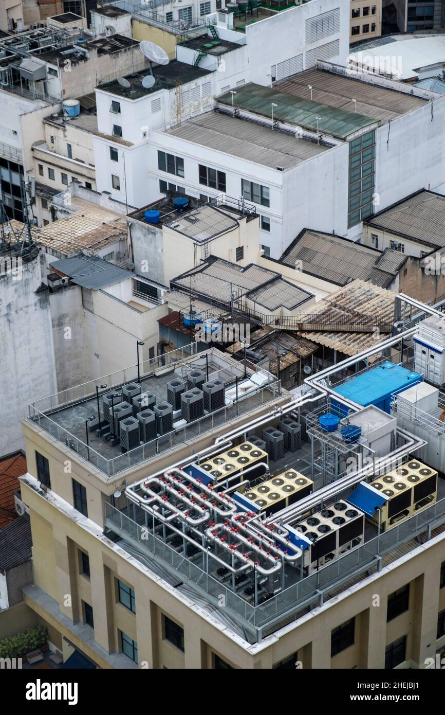 Unità di climatizzazione commerciali. Sfiati di scarico sul tetto di un alto edificio di uffici / appartamenti in un centro urbano occupato Foto Stock