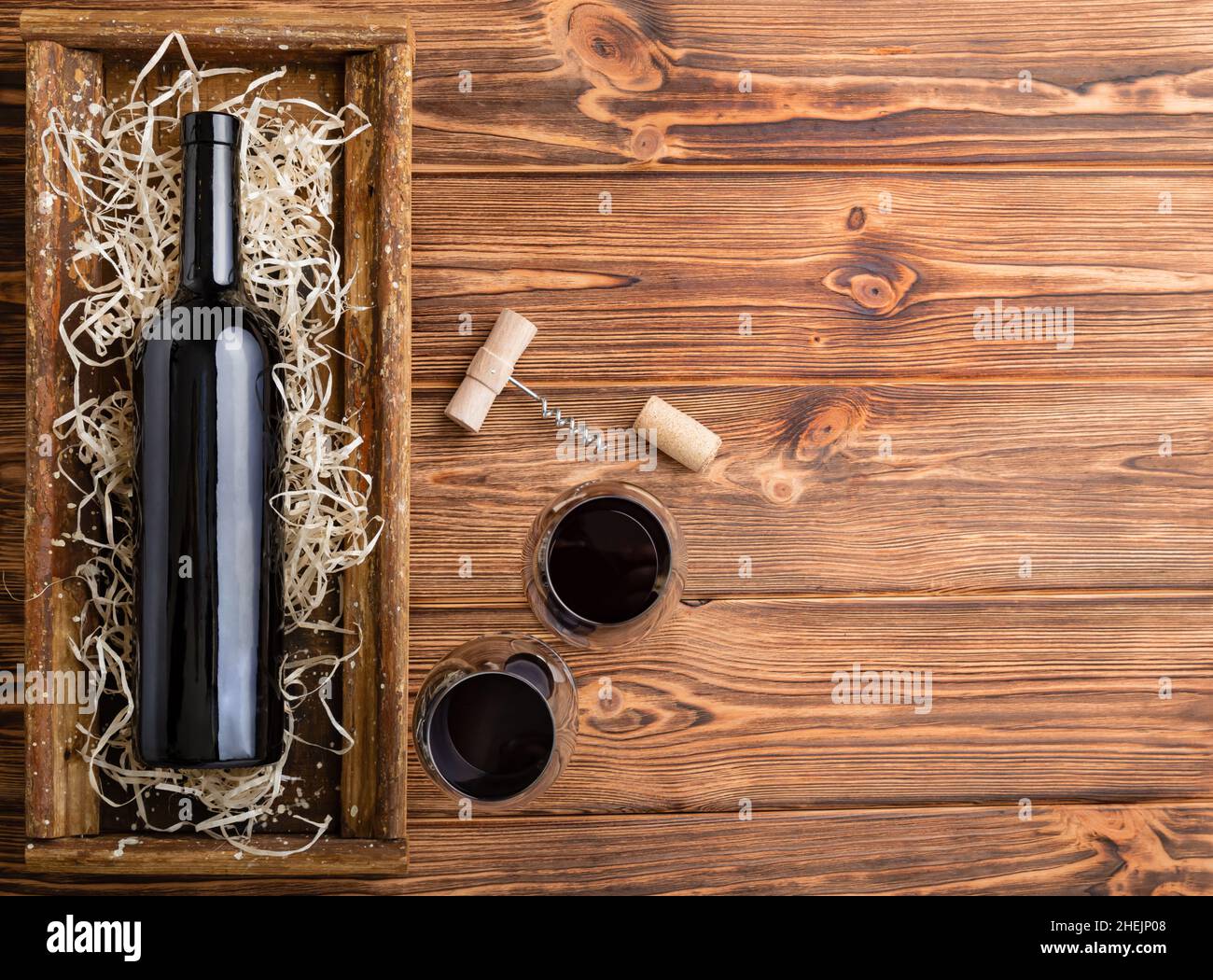 Composizione del vino rosso su tavola di legno marrone. Vista dall'alto. Bottiglia di vino rosso cavatappi bicchieri da vino su tavola di legno con spazio per la copia. Foto Stock