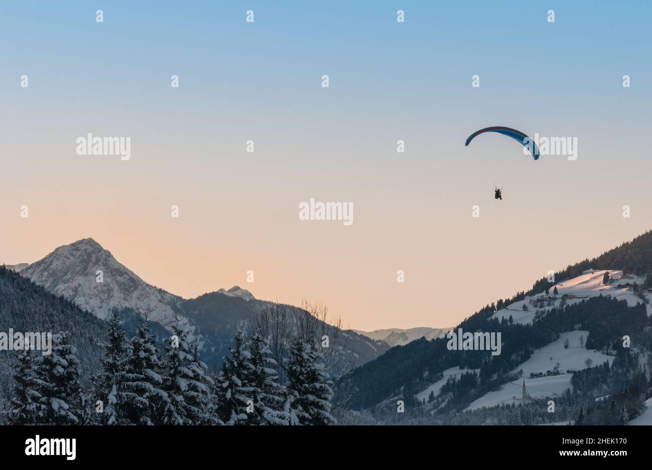 parapendio al tramonto sulle montagne innevate Foto Stock