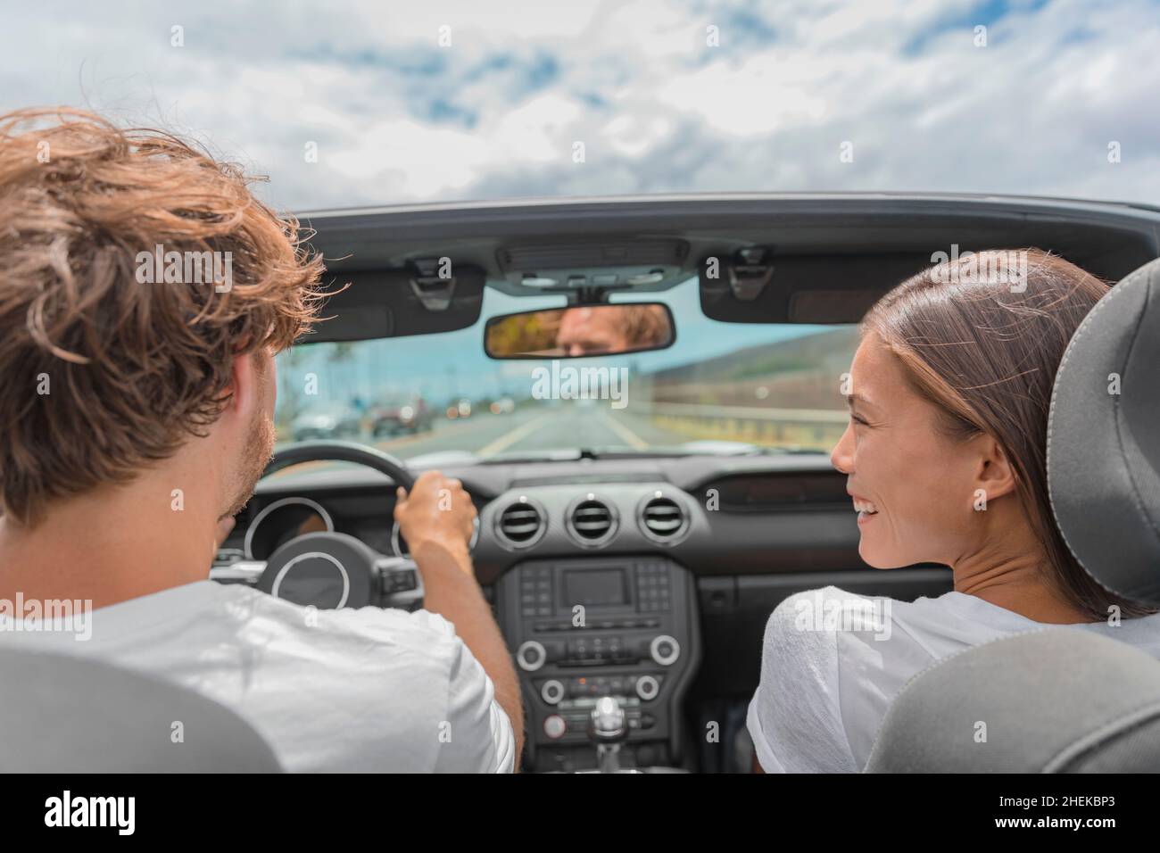 Auto viaggio uomo guida sportiva convertibile auto, ragazza asiatica che guarda sorridendogli. Vacanze estive di viaggio Foto Stock