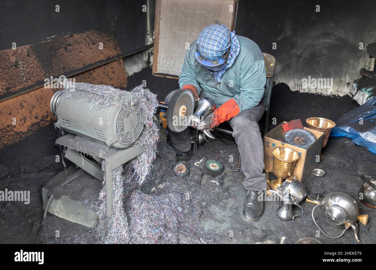 Ushaiqer, Arabia Saudita, 1st gennaio 2022: Uomo che lavora in un laboratorio polveroso, la produzione di caffè arabo pentole Foto Stock