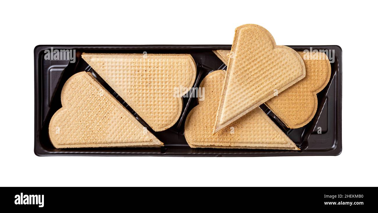 Wafer a forma di cuore per guarnire in un contenitore di plastica nero isolato su sfondo bianco. Biscotti con cialde sottili e piatti per la decorazione del gelato. Foto Stock