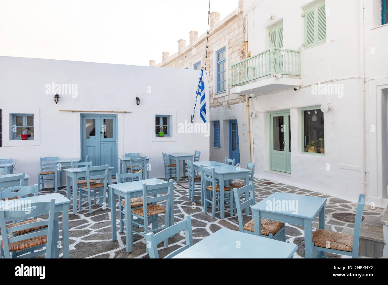 Grecia, Paros isola Naousa porto vecchio. Bar ristorante all'aperto, tavoli e sedie vuoti sul mare Foto Stock