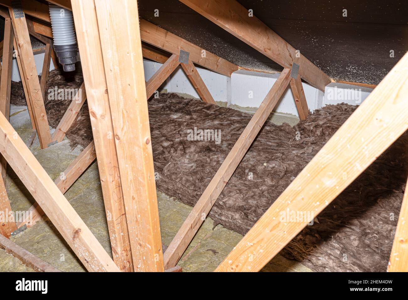 Lana di vetro posta su tubi in ventilazione domestica con recupero di calore, tubi posti su un traliccio del tetto. Foto Stock