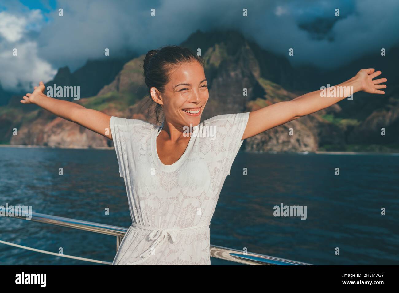 Divertimento crociera vacanza felice donna felice con le braccia aperte su Kauai Na Pali Coast nave tour guardando la costa di montagna. Stile di vita di viaggio estivo Foto Stock