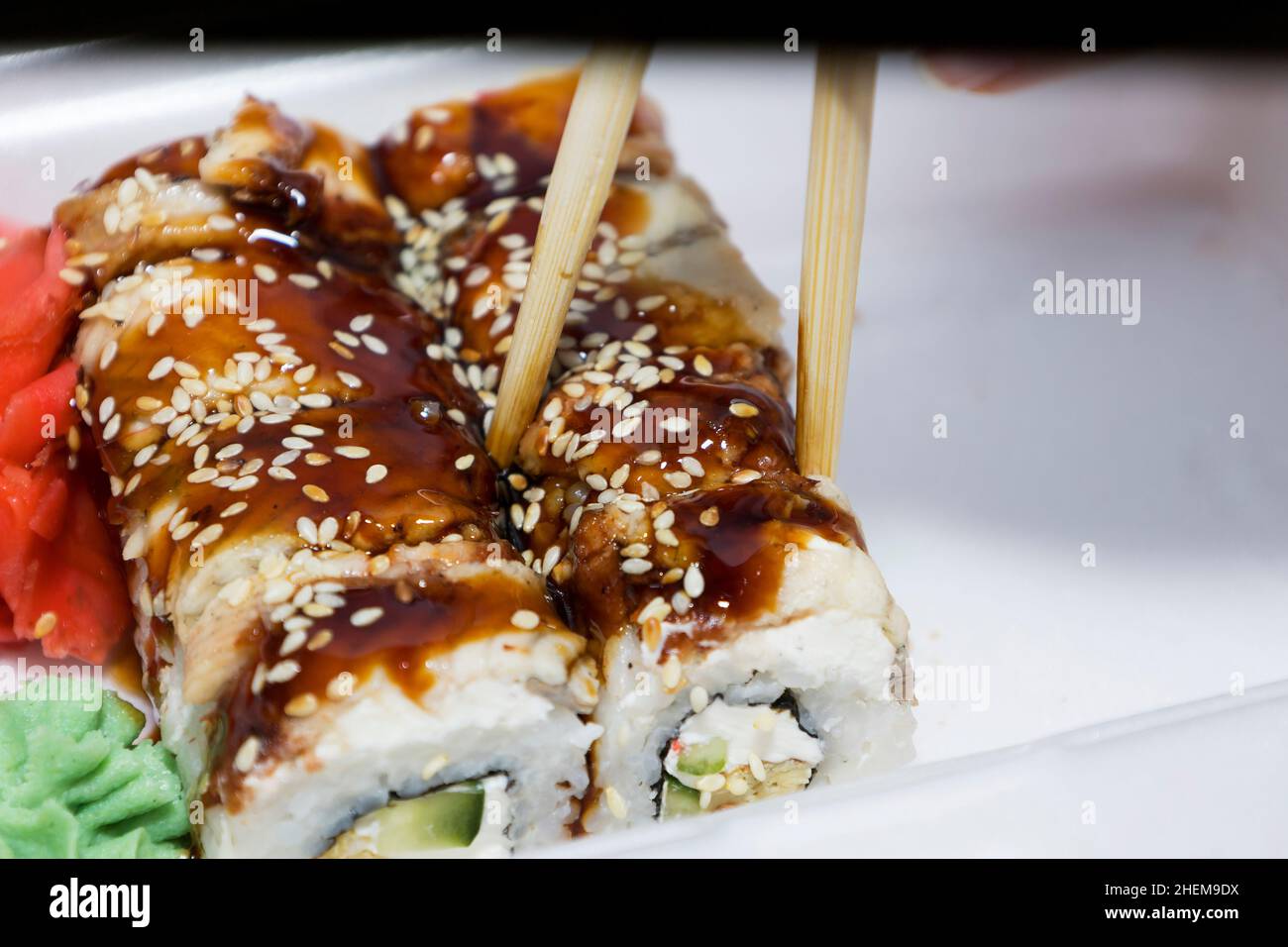 Sushi rotoli, su un piatto. Il sushi si attacca accanto ai panini. Cucina tradizionale giapponese Foto Stock