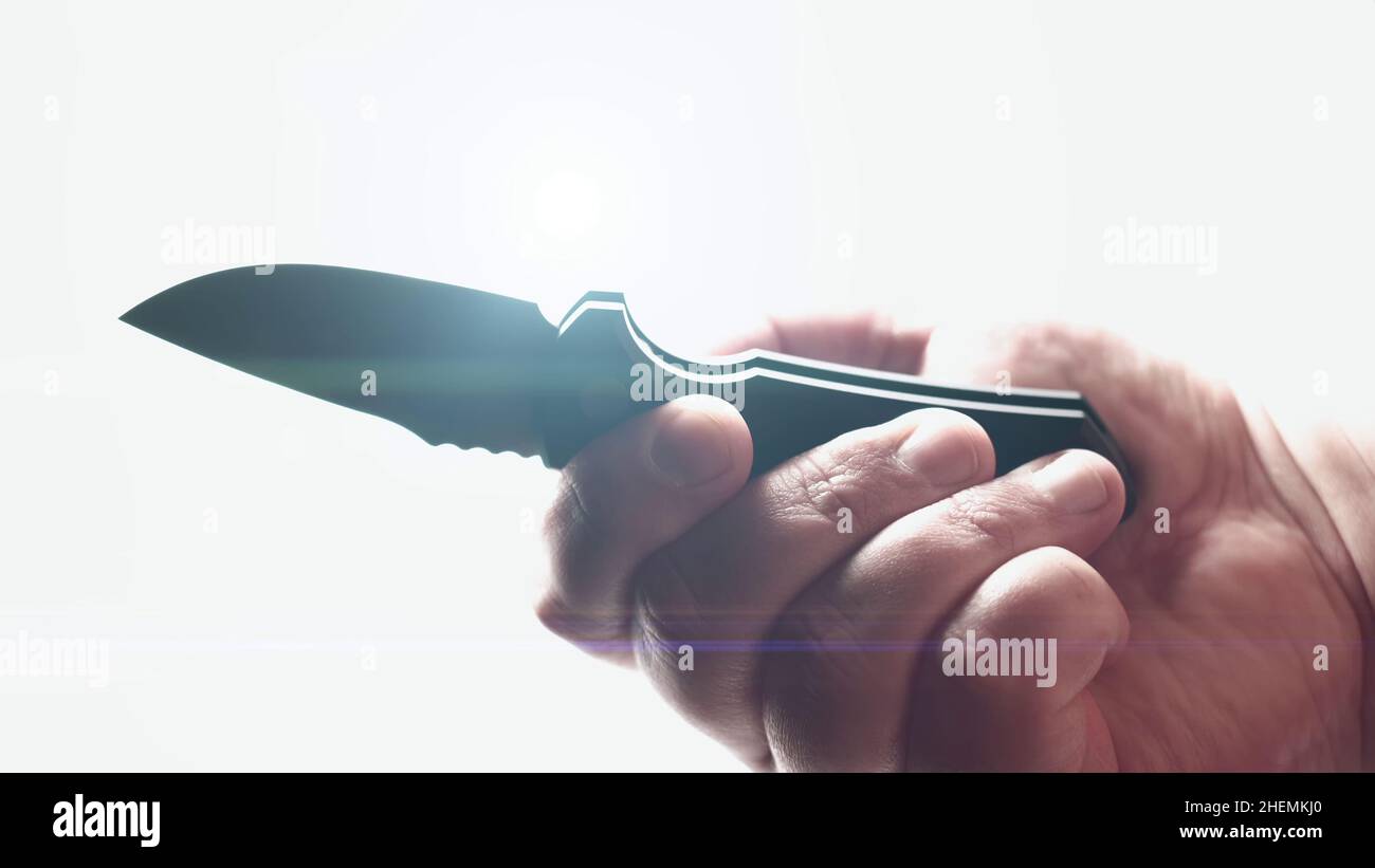 Coltello affilato in mano maschio. Lama di apertura coltello tasca pieghevole automatica EDC su sfondo bianco con lente svasata. Foto Stock