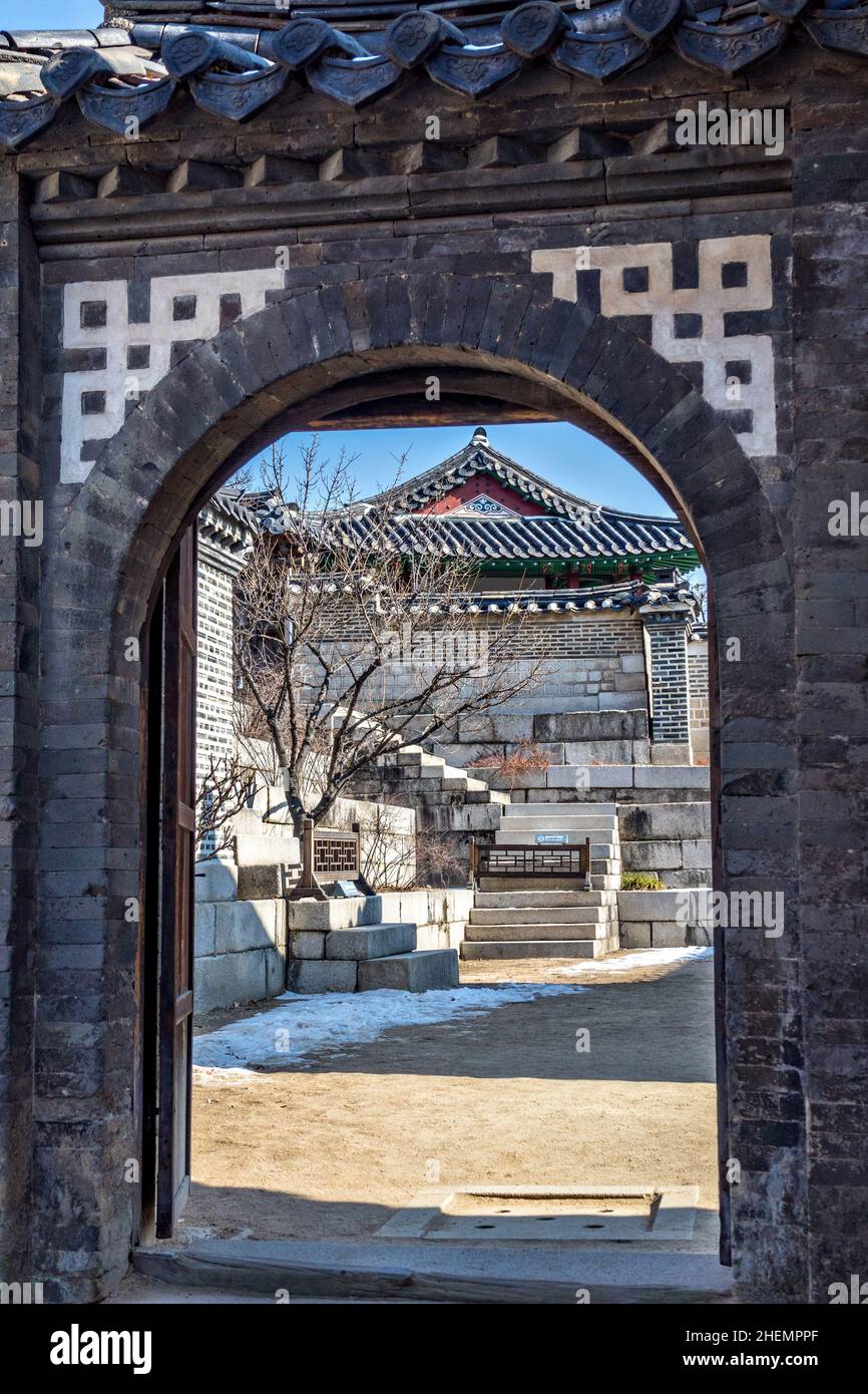 Un arco che conduce agli edifici del Gwolnaegaksa all'interno del Palazzo Changdeokgung durante l'inverno a Seoul, Corea del Sud. Foto Stock