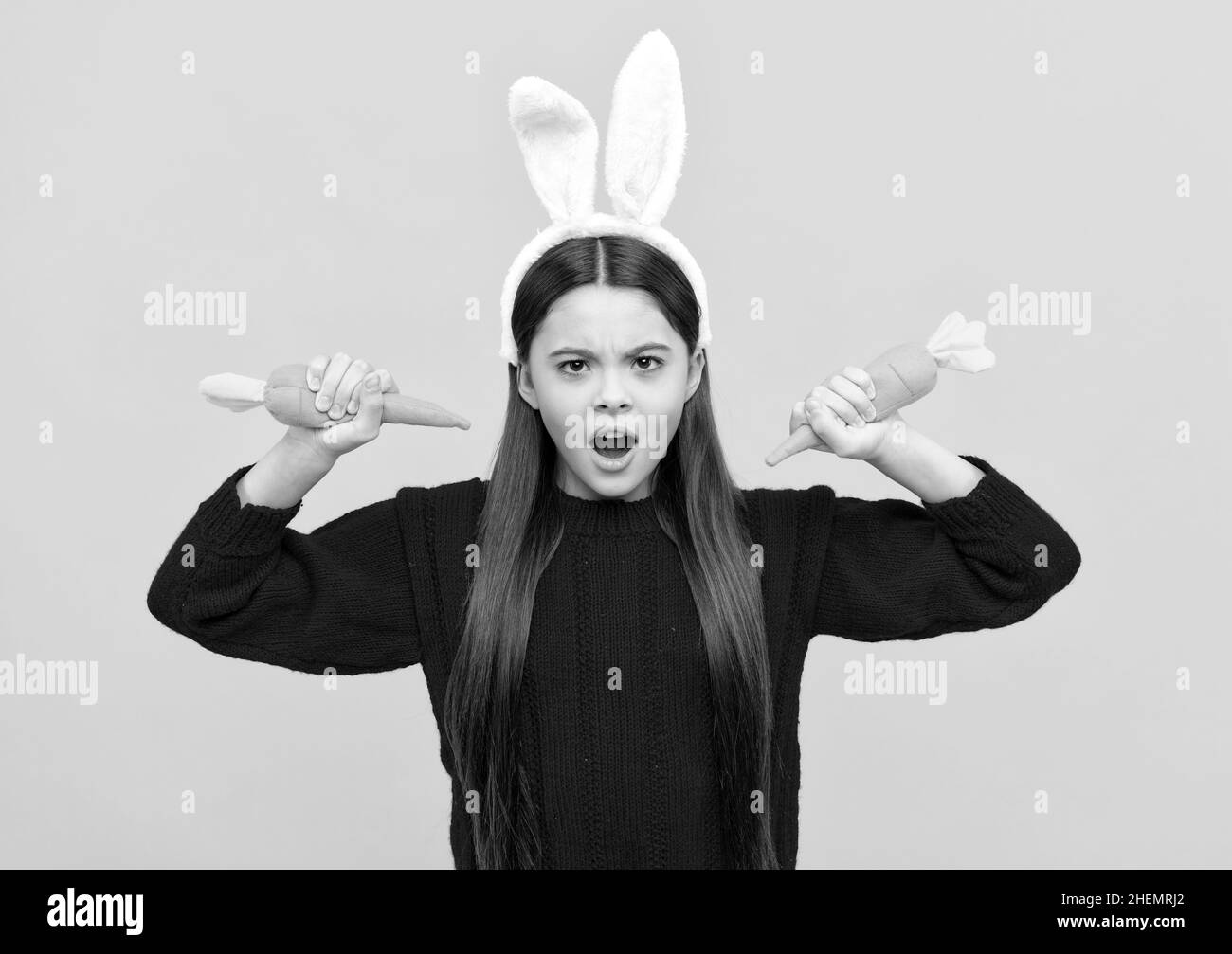 la lepre mangia le carote - 6 carota sana. bambino in costume di coniglio. tempo per il divertimento. adorabile bambino che indossa divertenti orecchie di lepre Foto stock - Alamy