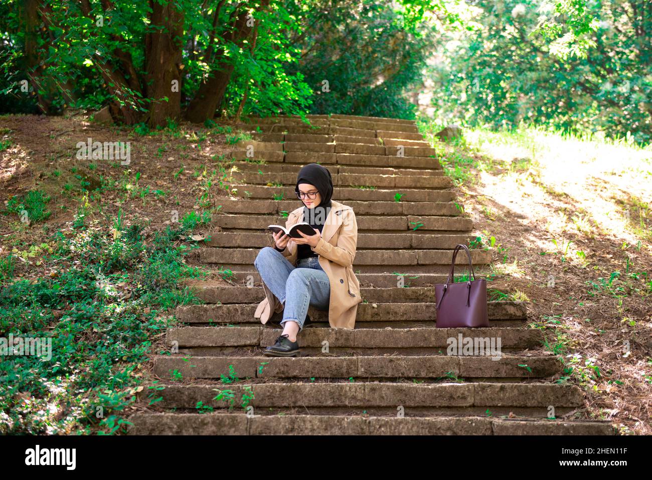 Donna musulmana che legge profondamente focalizzata e godente esso Foto Stock