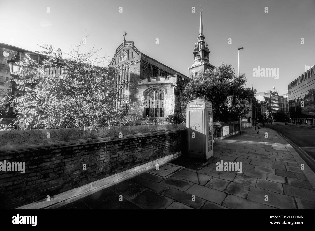 All Hallows-by-the-Tower, antica chiesa anglicana, Byward Street, City of London, Inghilterra, con cabina telefonica rossa in primo piano Foto Stock